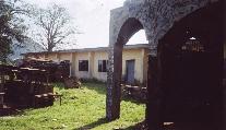 Damaged walls and propped roofing in the interior courtyard of the Ikere palace.