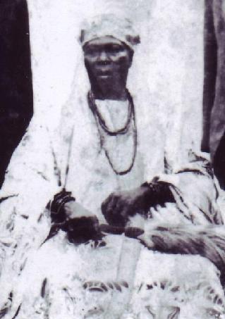 Archival full-length portrait of the Ogoga of Ikere in beaded crown and ceremonial regalia, late 19th to early 20th century.