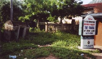 The gated entrance to the Palace at Ikere, with a painted welcome sign beside the road.